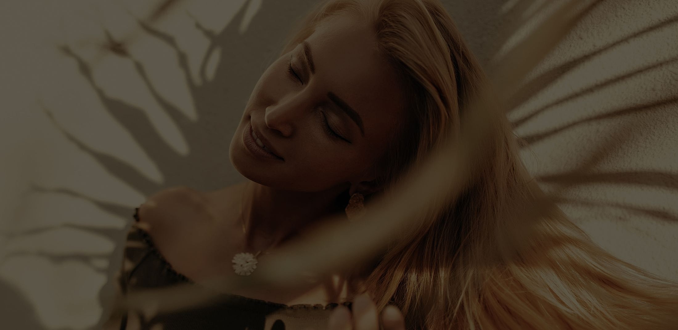 Woman enjoying sunlight with shadows around her.