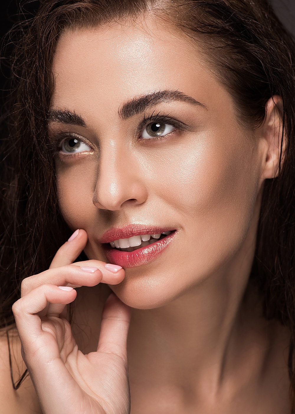 Close-up of a smiling woman with soft makeup.