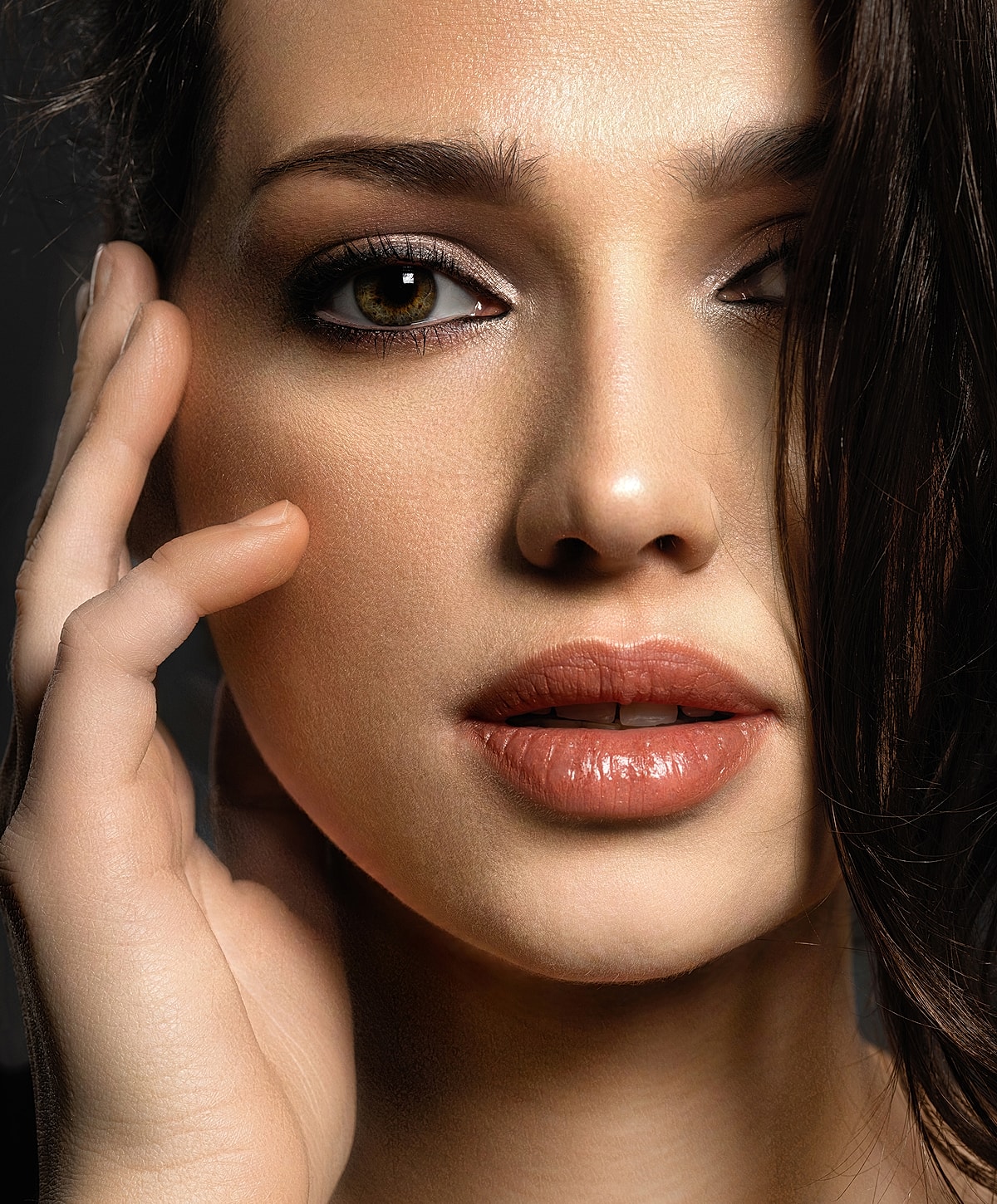 Close-up of a woman's face and hand.