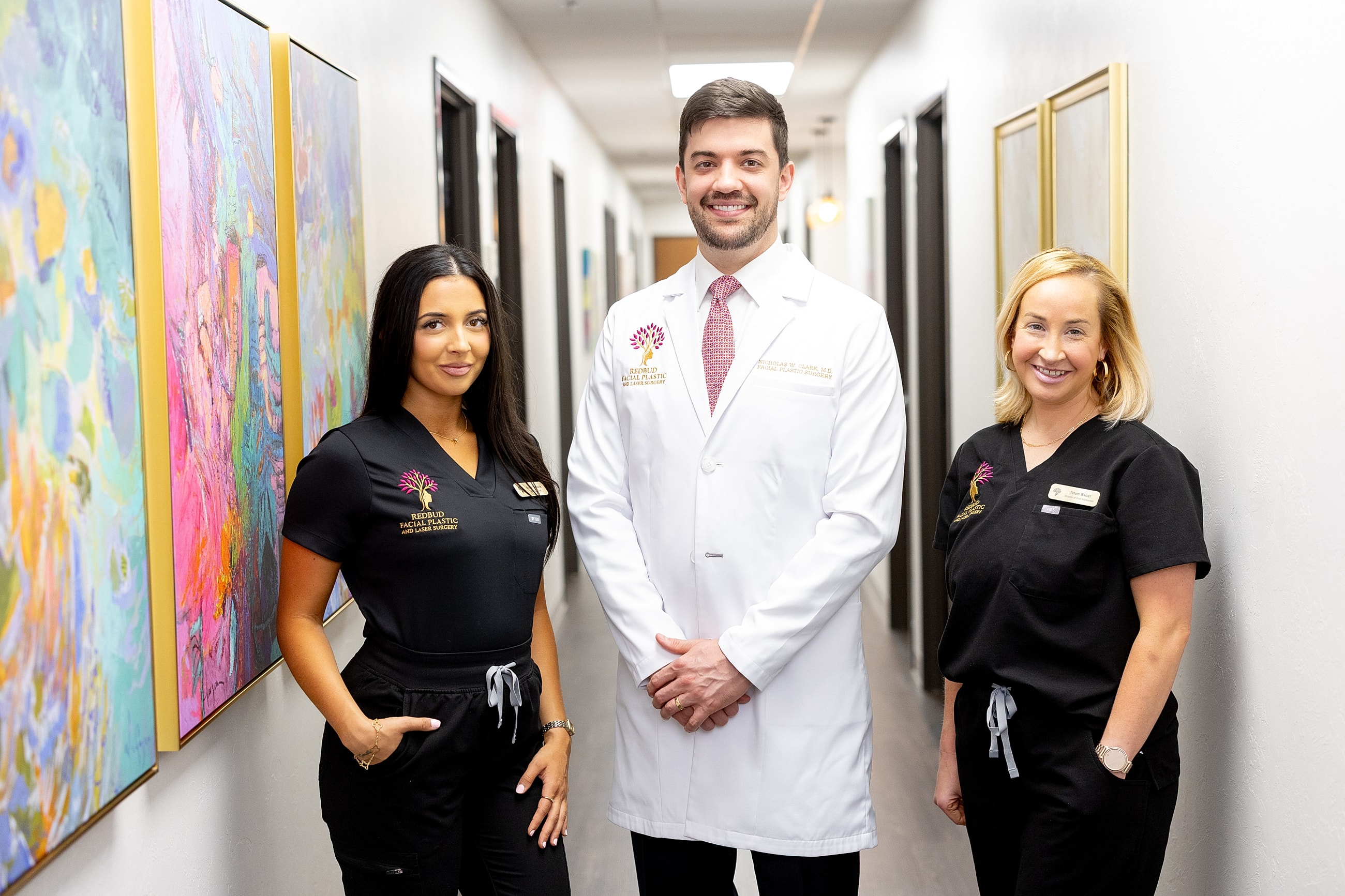 Healthcare professionals posing in a clinic hallway.