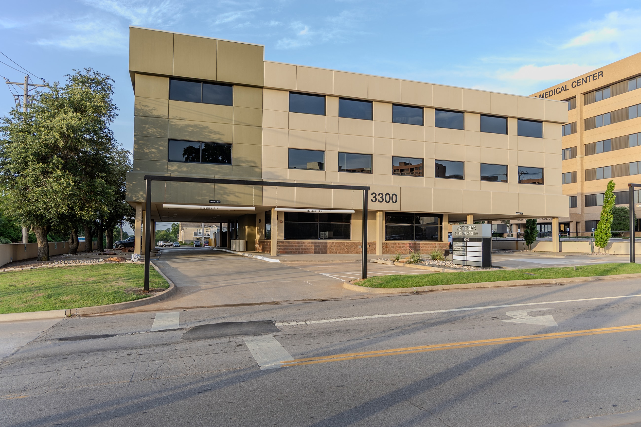 Modern medical center exterior with entrance driveway.