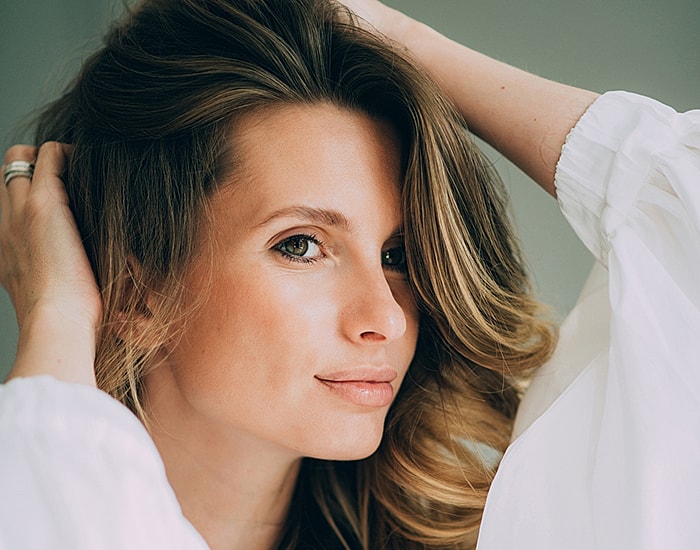 Woman with flowing hair and natural makeup.