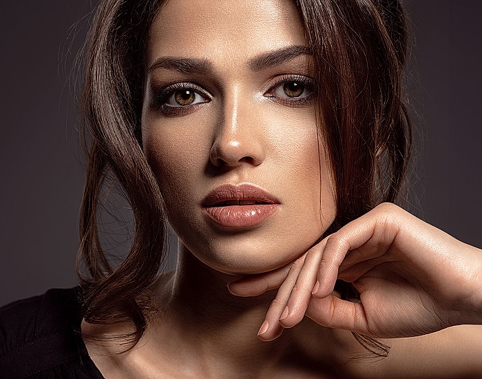 Portrait of a woman with brown hair and makeup.